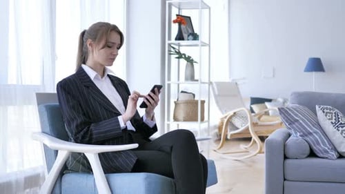 Young Woman Using Mobile Phone in Modern Living Room