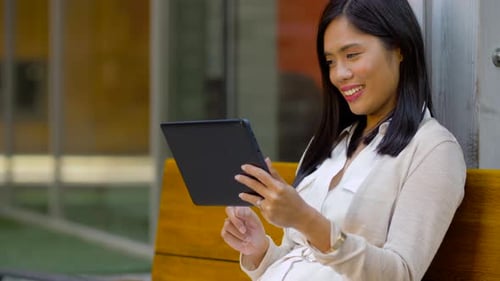 Woman Using Tablet While Sitting Outside