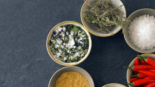 Assorted Spices and Herbs Arranged on Slate Surface