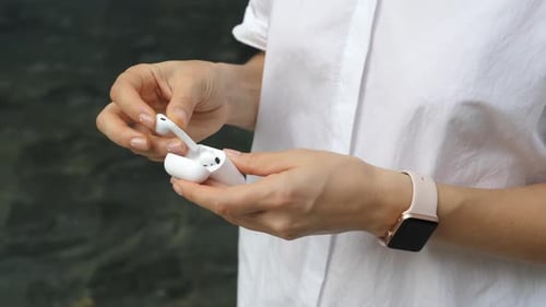 Woman Holding and Closing Wireless Earbuds Case