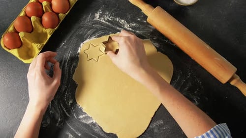 Hands Cutting Star Shapes From Cookie Dough