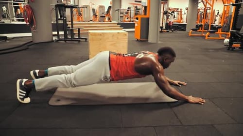 A man is doing some core training in the gym. This is a basic exercises.