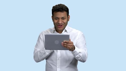 Ecstatic Man Surprised by Content on Tablet