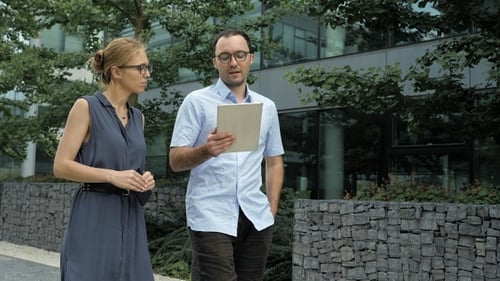 Business Colleagues Discussing Work on Tablet Outdoors
