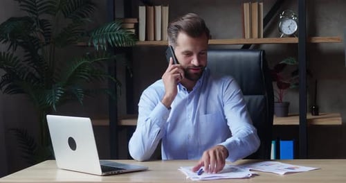 Adult Man Working at Desk Talking on Phone