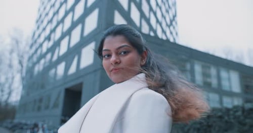 Indian woman looking to the camera outside a building
