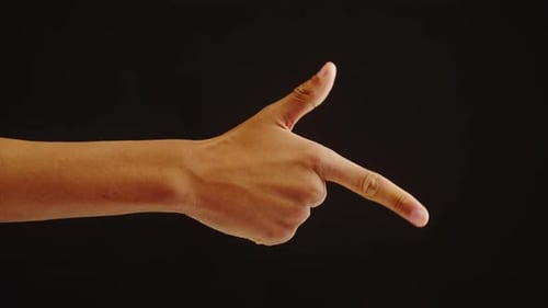 Hand Making Gun Shape Against Black Background