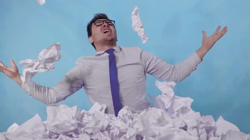 Furious Man Office Worker Leans Out of a Large Heaps of Crumpled Paper