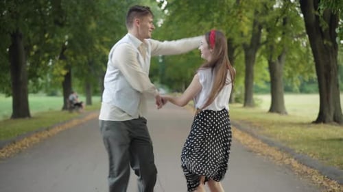 Cheerful Dance of Happy Carefree Couple in Sunny Summer Park, Joyful Young Caucasian Man and Woman