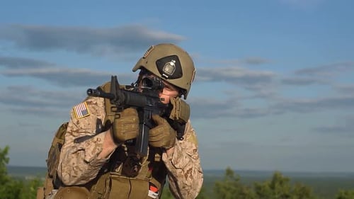 Man aiming a rifle in military gear
