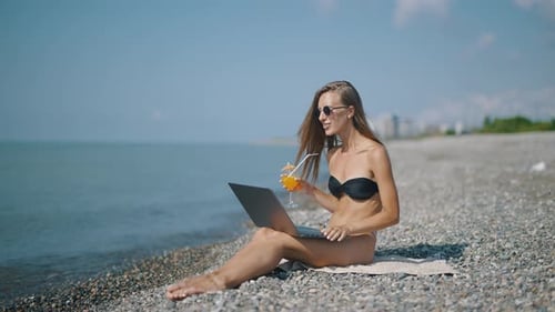 A Attractive Woman Blogger or Vlogger is Recording Content for Channel and Looking at Laptop and