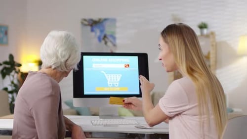 Young Woman Teaching Senior Woman Online Shopping