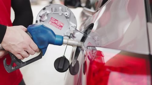 Benzin an der Tankstelle pumpen. Nahaufnahme einer Hand, die Kraftstoff hält