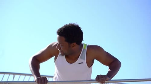 Muscular Man Doing Push Ups on Bar Outdoor