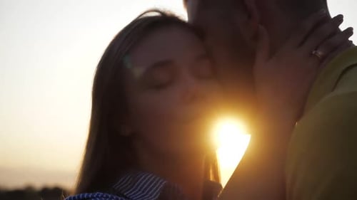 Close-up Shooting of Loving Cute Couple Kiss on a Romantic Date Against the Sunset. Close View of