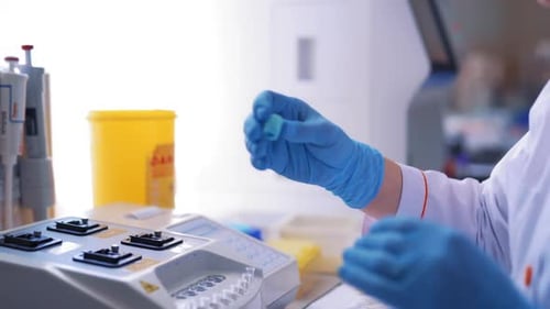 Modern medical laboratory equipment. Side view of adult female scientist experimenting in laboratory