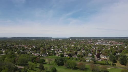 Panoramablick auf die Stadt im Tal in Wisconsin, strahlend blauer Himmel, wispy Wolken, Berge, Wald.