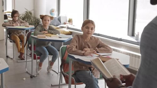 Kluge Kinder heben ihre Hände im Klassenzimmer