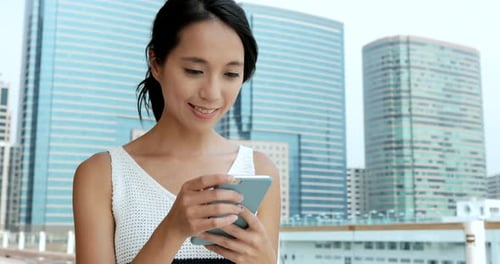 Woman using smart phone in the city