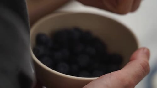 Adding Fresh Blueberries to Frosting-Covered Cake, Close Up
