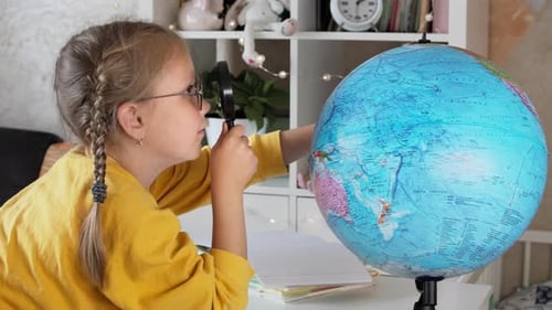 Girl Studying Globe With Magnifying Glass