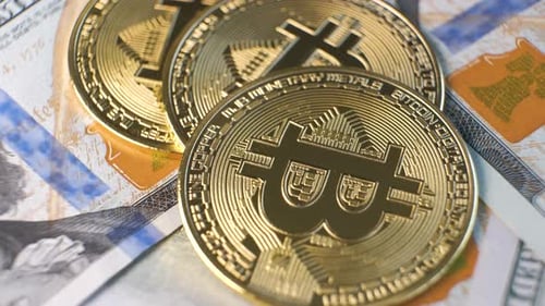 Gros plan des pièces de monnaie cryptographiques Bitcoin brillantes en métal sur des billets en dollars américains