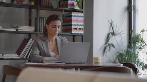 Woman Working on Laptop at Desk Indoors