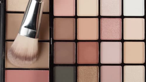 Makeup Brush Swirling on Colorful Eye Shadow Palette