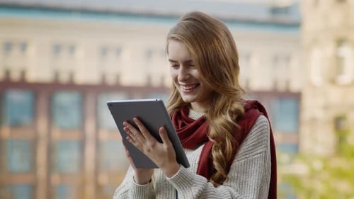 Smiling Woman Using Tablet Outdoors