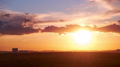 The morning sun rising above the horizon, the landscape at dawn. Summer sunrise, timelapse
