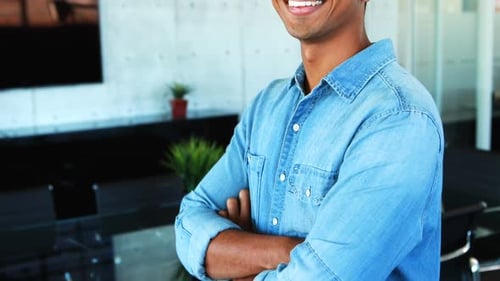 Male executive standing with arms crossed in office 4k
