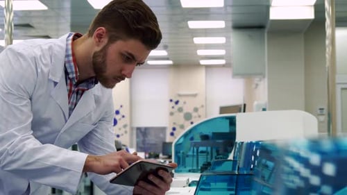 Man überprüft die Arbeit des Laborgeräts mit dem Tablet
