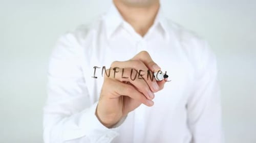 Man Writing Word Influence on Glass Board