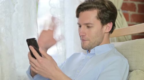 Porträt eines jungen Mannes beim Video-Chat auf dem Smartphone