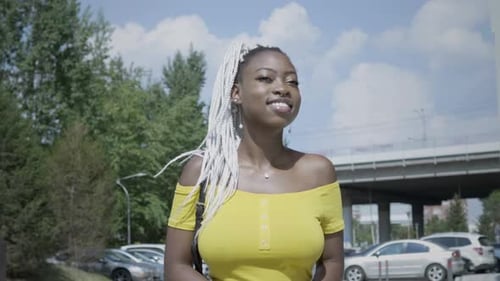 Smiling Woman Uses Phone on City Street