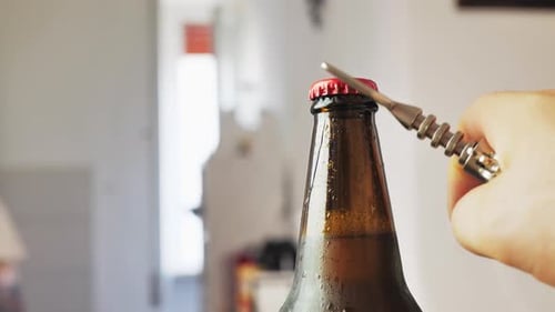 Men's Hands Open Bottle of Beer