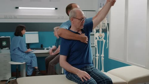 Therapist Assists Senior Man with Arm Exercises