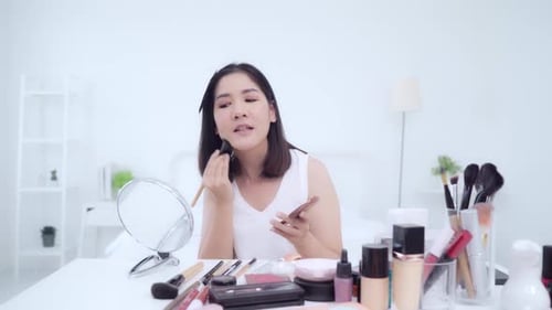 Joven asiática usa cosmética reseña tutorial de maquillaje retransmite vídeo en directo a la red social.