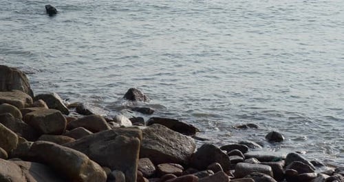 Sea wave on rock stone at sunset