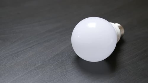 Weiße LED-Lampe Ersatz für klassische Glühbirnen auf Holztisch Slow Tilt 4K 2160p 30fps UltraHD Fuß