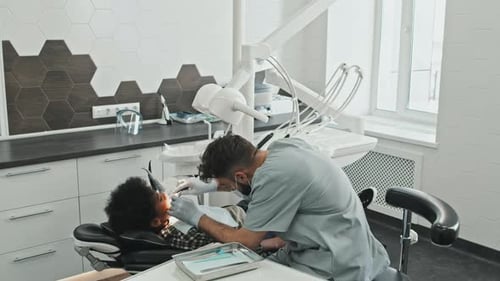 Dentist Checking Child's Teeth in Modern Office