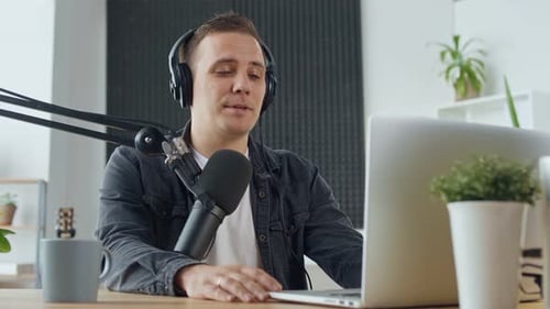 Man Recording Podcast at Desk with Laptop