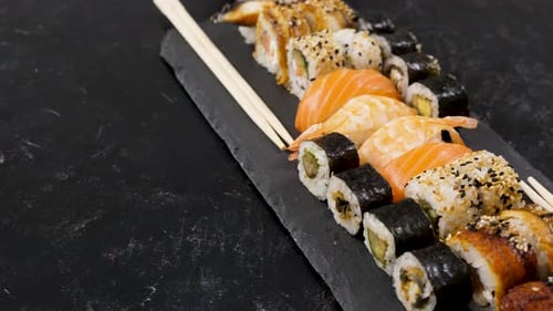 Rolls of Traditional Sushi on Black Stone Plate