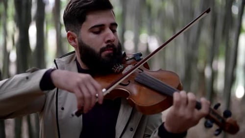 Young Adult Man Playing Violin in Forest