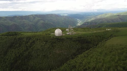 Aerial View of Observatory on Hilltop with Mountains