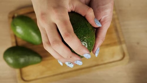 Avocado Cut in Half on Cutting Board