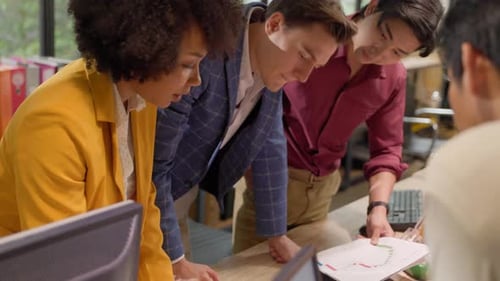 Diverse Team Reviewing Charts in Office
