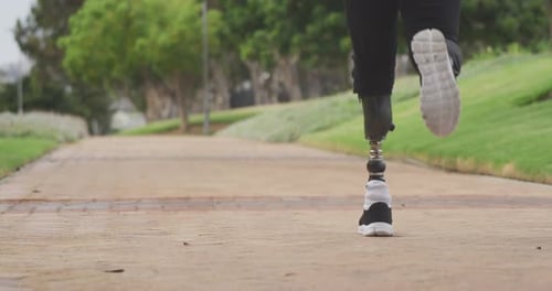 Rear view man with prosthetic leg running