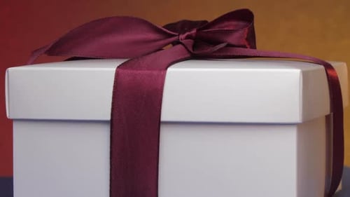 Boîte en carton cadeau blanche avec ruban violet et nœud
