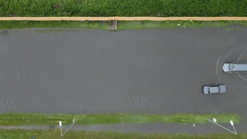 Aerial View of City Traffic with Cars Driving on Flooded Street After Heavy Rain